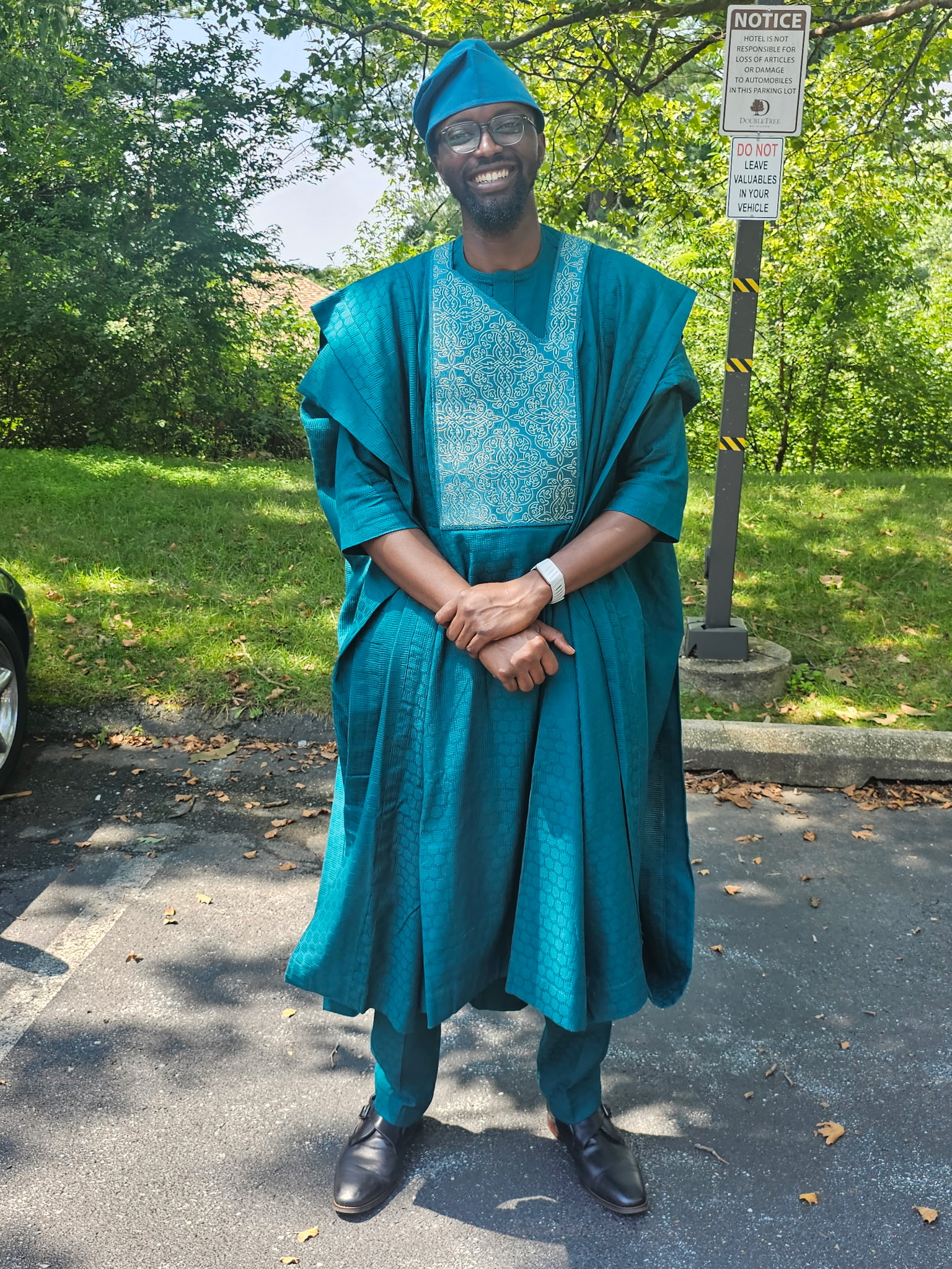 Victor standing outdoors in blue formal traditional dress
